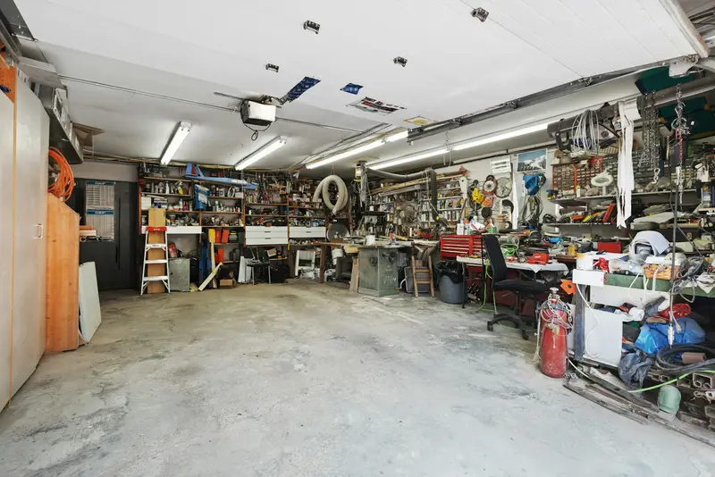 Volle Garage mit Werkzeug, Regalen und Kisten vor der Entrümpelung