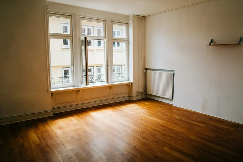 Leere, helle Wohnung mit Holzboden nach der Räumung